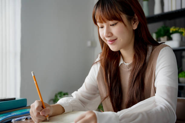 istock Asian woman using laptop to study student engaged in online learning at college 2190541820