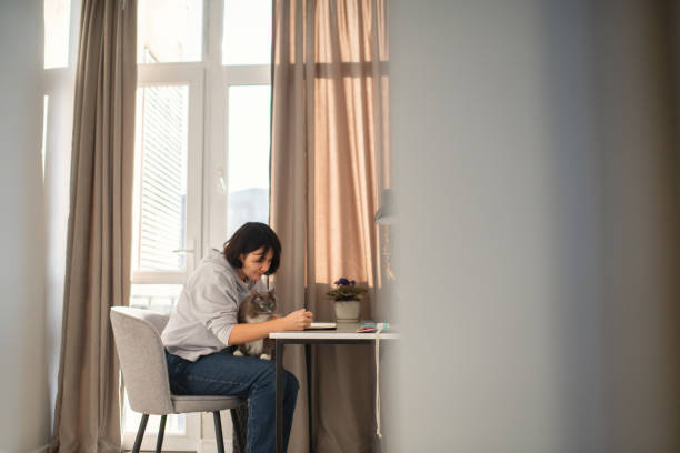 istock Woman studying or working at home with her cat 2190545986