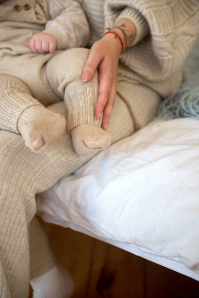 istock Mom's hands. baby's legs. baby is dressed. 2190546184