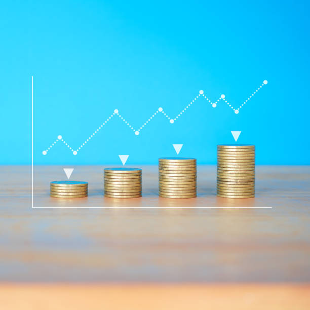 istock Golden money coin stack on blue background with graph and dot graph. Minimal financial background concept. 2190547371