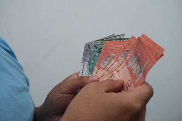 istock Close up of man hand showing Malaysian Ringgit banknotes 2190549151