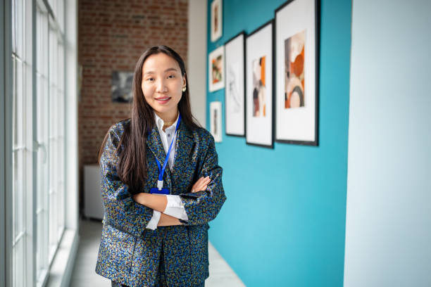 istock Art gallery curator standing confidently in front of framed artworks display 2190549664