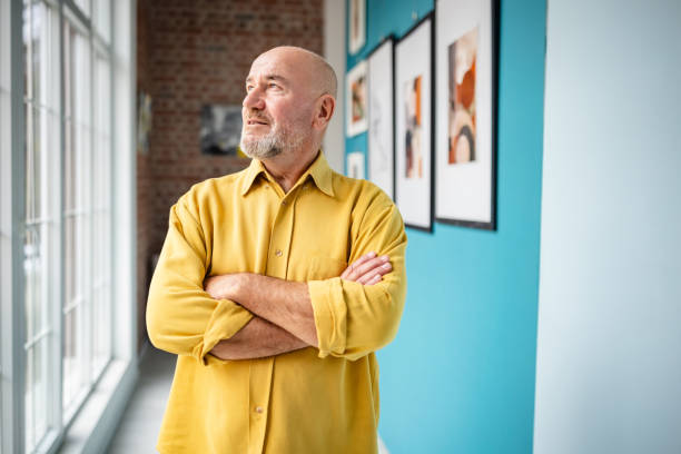 istock Mature man in art gallery observing framed artwork with thoughtful expression 2190549723