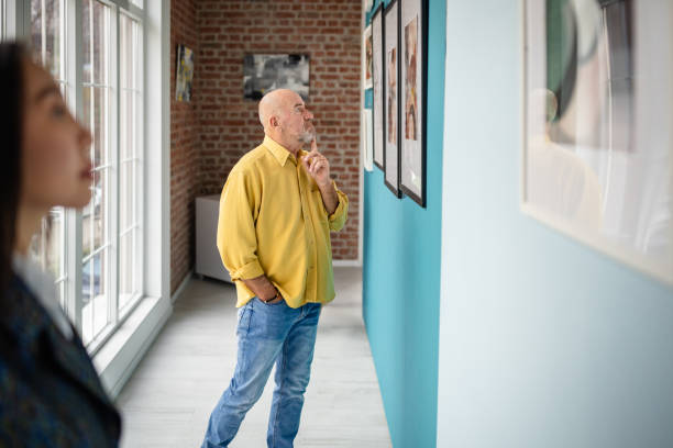 istock Visitors Engaged in Observing Art Exhibits at a Modern Gallery 2190550335