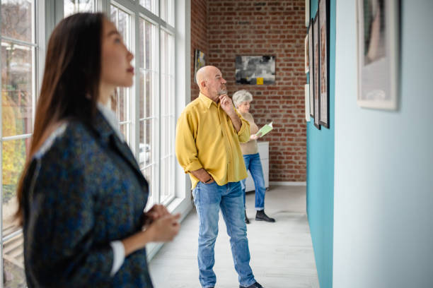 istock Art gallery visitors viewing artwork with curator guiding the experience 2190550363