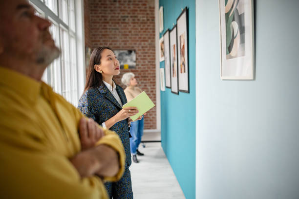 istock Curator and visitors exploring paintings in a modern art gallery setup 2190551394