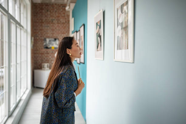 istock Asian woman curating art exhibition in a modern gallery setting 2190551490