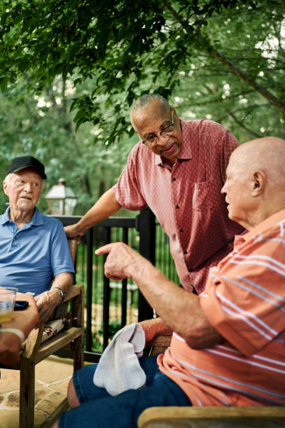 istock Retired men chatting at table in home backyard 2190551782