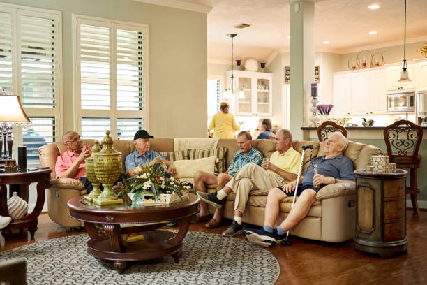 Senior friends relaxing and chatting on couch at home
