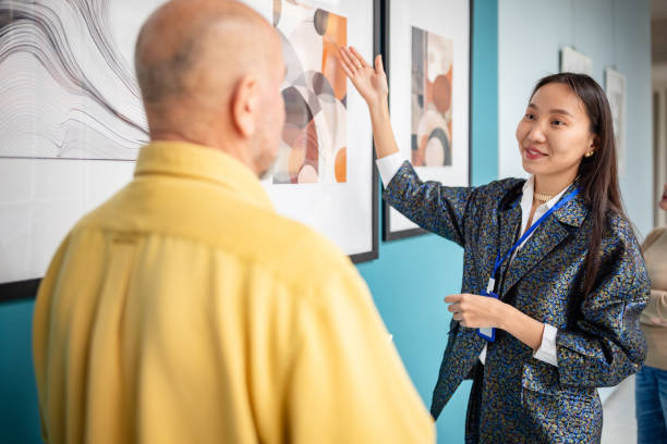 istock Art gallery curator explaining artwork to a visitor during a guided exhibition 2190552053