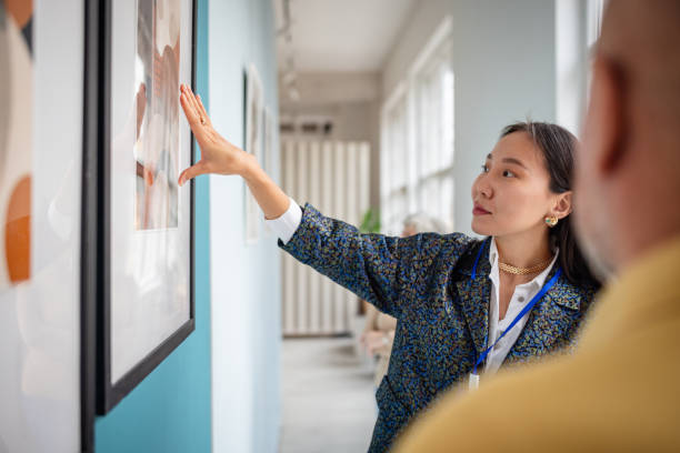istock Art curator presenting gallery artwork to visitors in a modern exhibition setting 2190552452