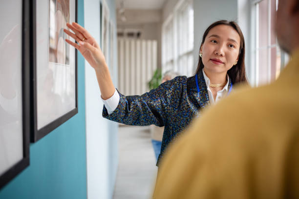 istock Art curator discussing framed pictures in a modern gallery exhibit setting 2190552549