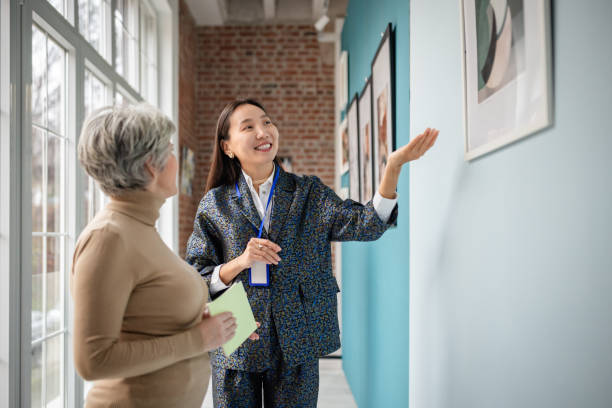 istock Art gallery curator discussing artworks with a visitor in an elegant setting 2190552663
