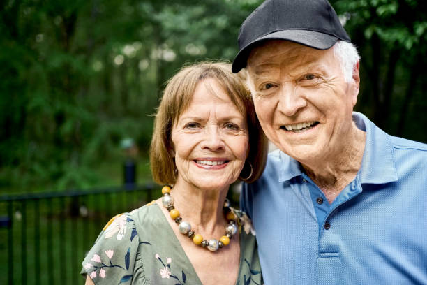 Portrait of smiling senior couple in backyard garden stock photo