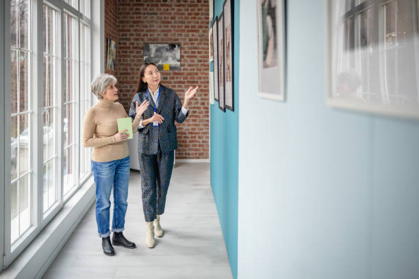 istock Curator discussing art with visitor in modern gallery exhibition space 2190552796