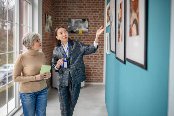 istock Curator Guiding Visitor in Contemporary Art Gallery Hallway Setting 2190552822