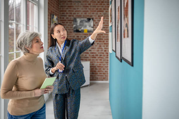 istock Art curator explaining exhibit to interested visitor in modern gallery setting 2190552839