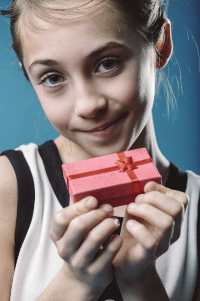 istock Smiling child holding a small gift box 2190553106