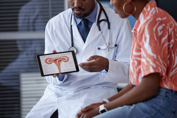 istock Black Male Obgyn Holding Tablet Displaying Female Reproductive System 2190554535