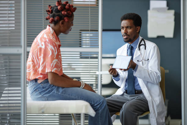 istock Black Doctor Holding Tablet Explaining Diagnosis to Woman 2190554588