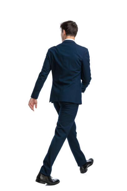 istock young businessman in navy blue suit looking to side and walking 2190555405