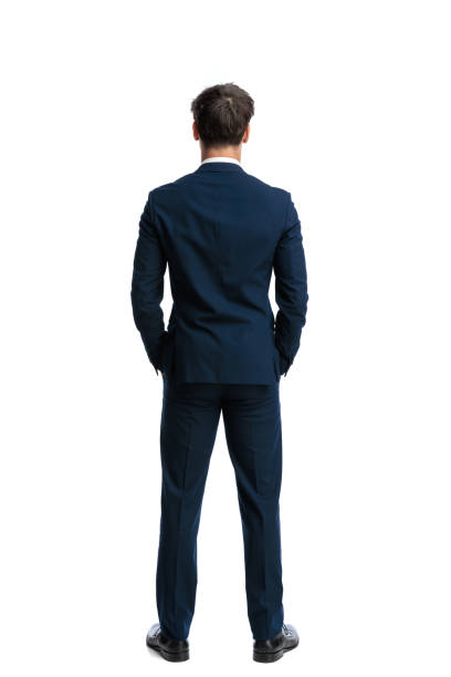 istock elegant young businessman standing with hands in pockets 2190555501