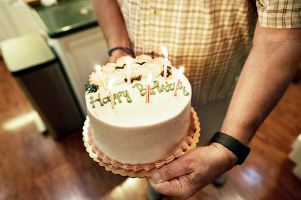 Close-up of a senior man carrying a birthday cake in a retirement home