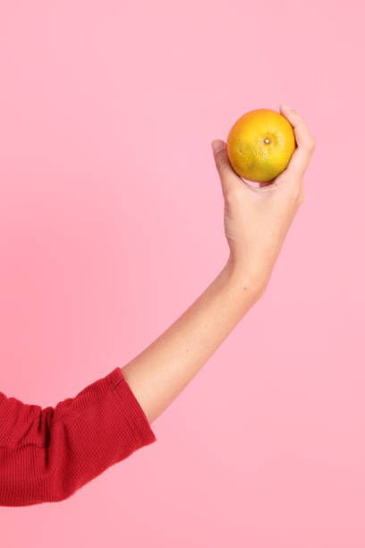 istock hand holding Tangerine or Orange 2190562187