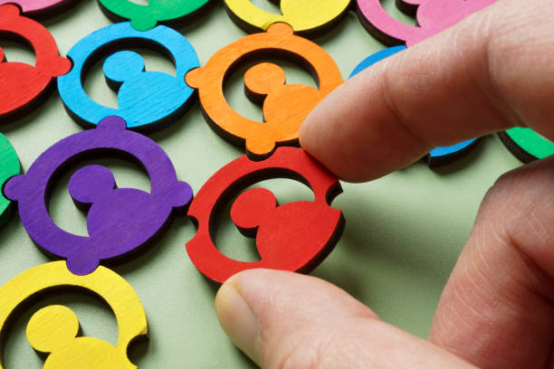 A hand adding piece to a colorful puzzle. Diversity and team collaboration.