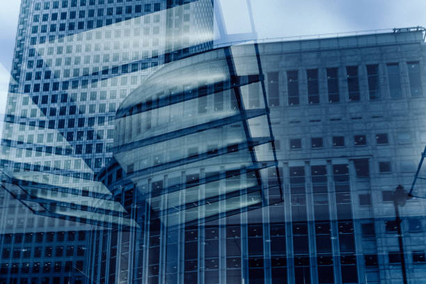 Dominating the canary wharf skyline, one canada square and surrounding buildings highlight london's modern architecture and financial strength under a cloudy sky