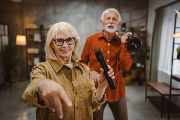 senior woman sing karaoke on microphone with senior man behind her