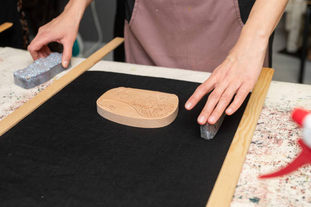 istock Female artisan setting up woodblock for printmaking on black fabric 2190569123