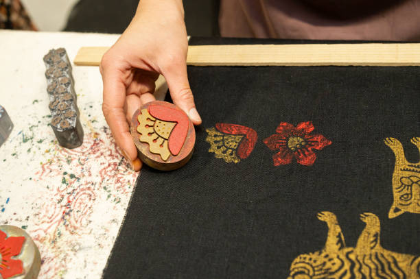 istock Female hand stamping textiles with colorful patterns and designs 2190569132