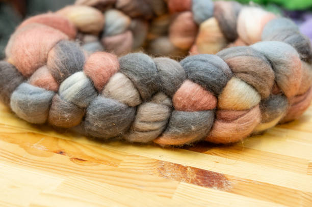 istock Hand-dyed wool roving in earth tones on wooden surface 2190569183