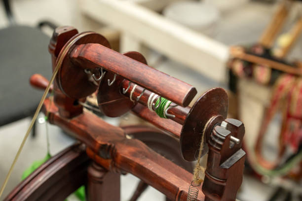 istock Distaff Day Wooden spinning wheel with yarn and hooks in workshop setting 2190569193
