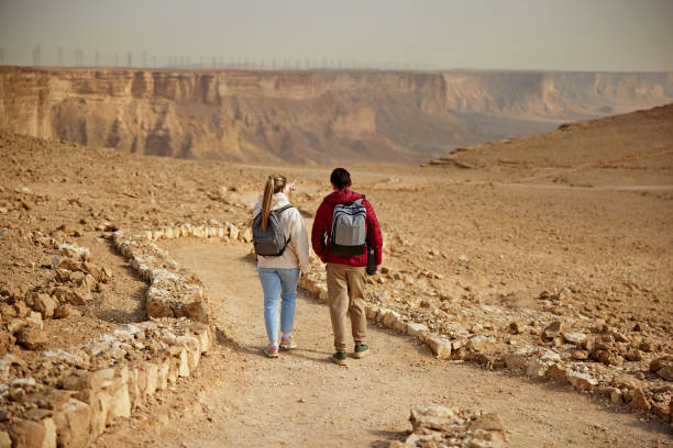 istock Rear view from couple admiring escarpment view from mountain trail 2190569561