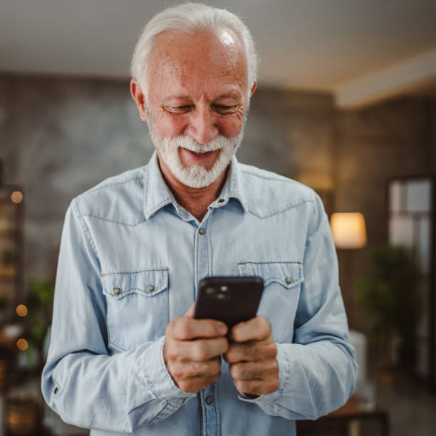istock senior man have fun while use mobile phone at home 2190572211