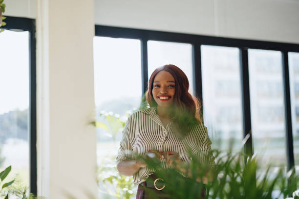 istock Smiling Professional in Modern Office Space With Green Plants and Natural Light 2190572356