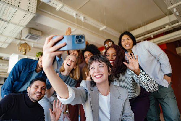 Diverse Group of Professionals Smiling and Taking a Selfie in a Modern Office
