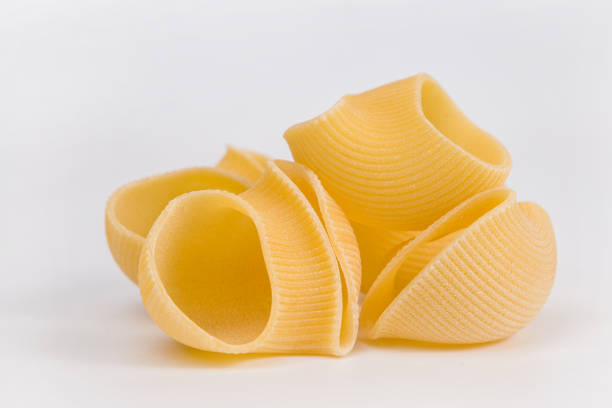 istock Pasta shells on a white background, close-up. Italian lumaconi pasta. 2190574706
