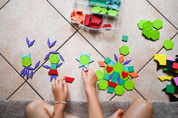 Little girl playing with tangram puzzle.