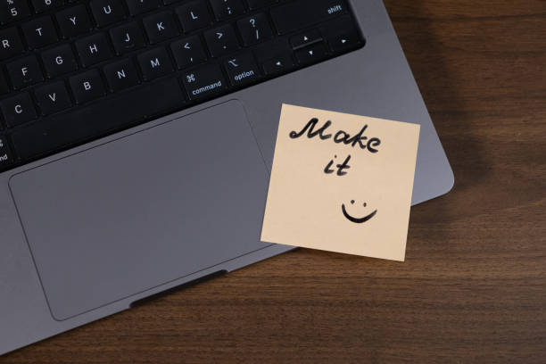 istock motivational note with handwritten message make it and smiley face on a laptop trackpad, workplace inspiration 2190577295