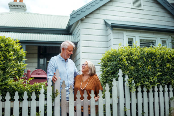 istock Senior couple bonding while standing near fence in their front yard 2190577461