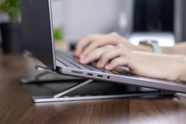 istock Hands typing on a laptop with an ergonomic stand for improved workspace posture and efficiency 2190577631