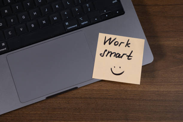 istock motivational sticky note with handwritten work smart message and smiley face on laptop trackpad, productivity concept 2190577739