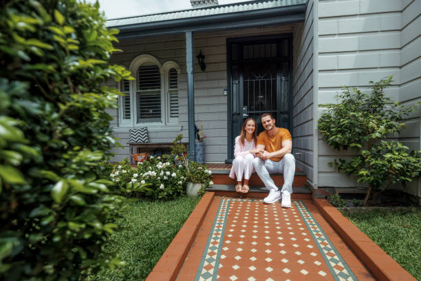 istock Married couple posing for camera while sitting in front of their home 2190577806