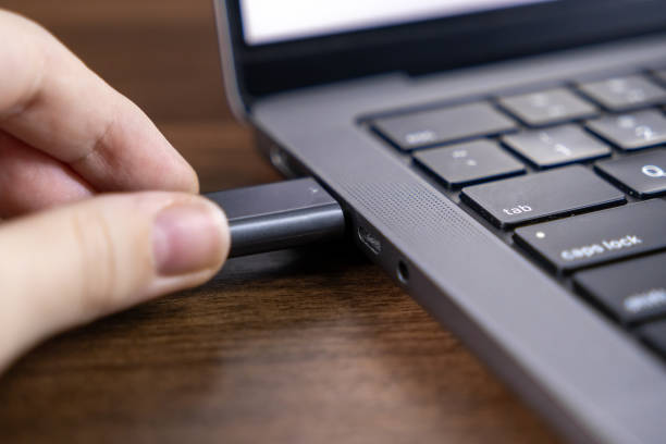 istock usb flash drive being inserted into laptop usb-c port for file transfer and data backup on wooden desk 2190578596