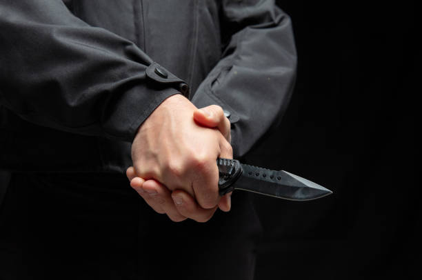 istock Criminal holding a knife with both hands closeup, armed attack concept. 2190582546