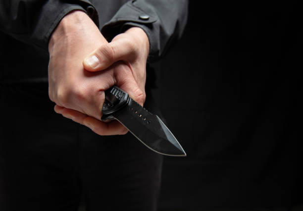istock Criminal holding a knife with both hands closeup, armed attack concept. 2190582563