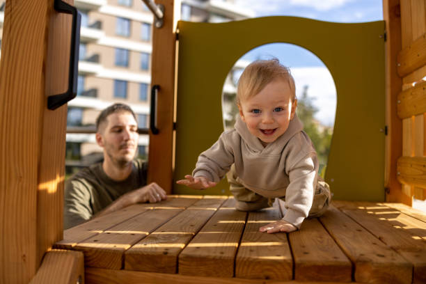 istock Crawling baby boy on playground with father 2190585533